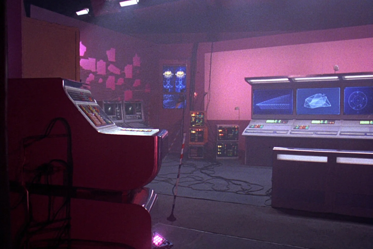 Sala de control retro-futurista con pantallas de datos en magenta y cian
